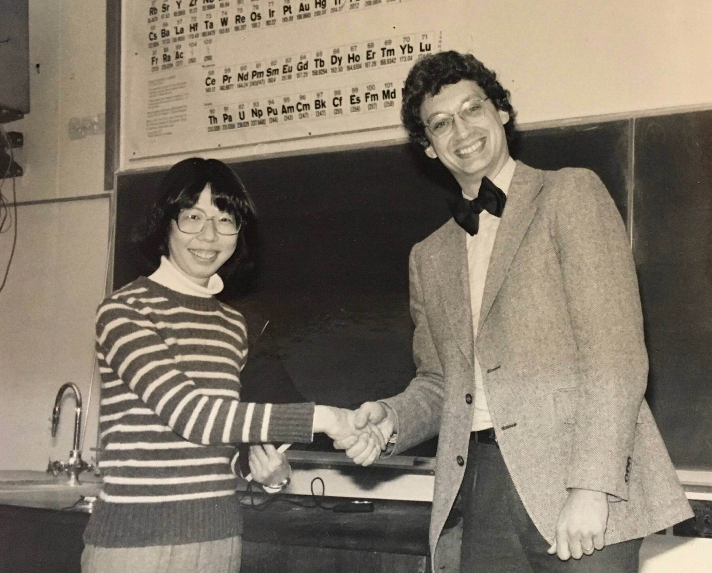 Old black and white photo of student and teacher shaking hands