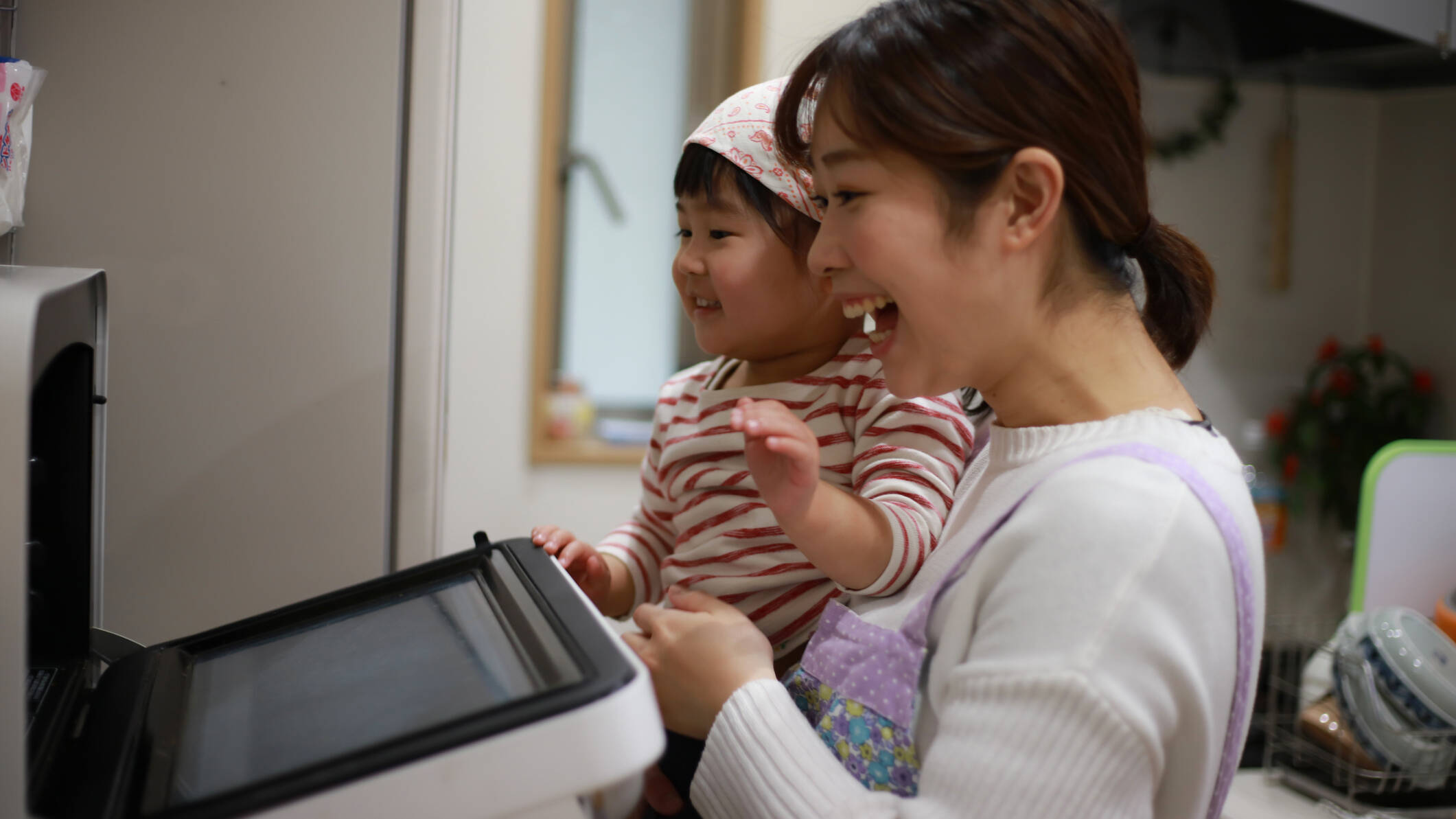 happy woman and child opening oven door