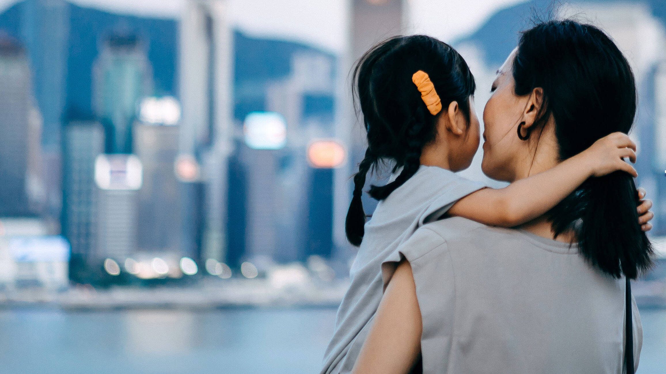 Woman holding child while viewing the cityscape