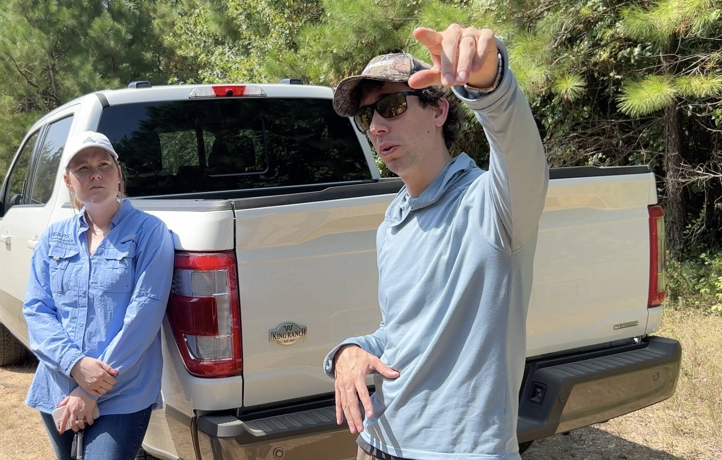 Male wearing hat and glasses standing next to truck