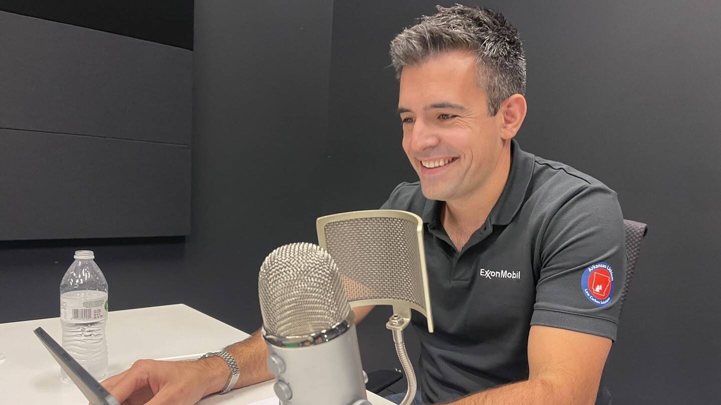 Patrick Howarth sitting in front of a iPad and podcast microphone.