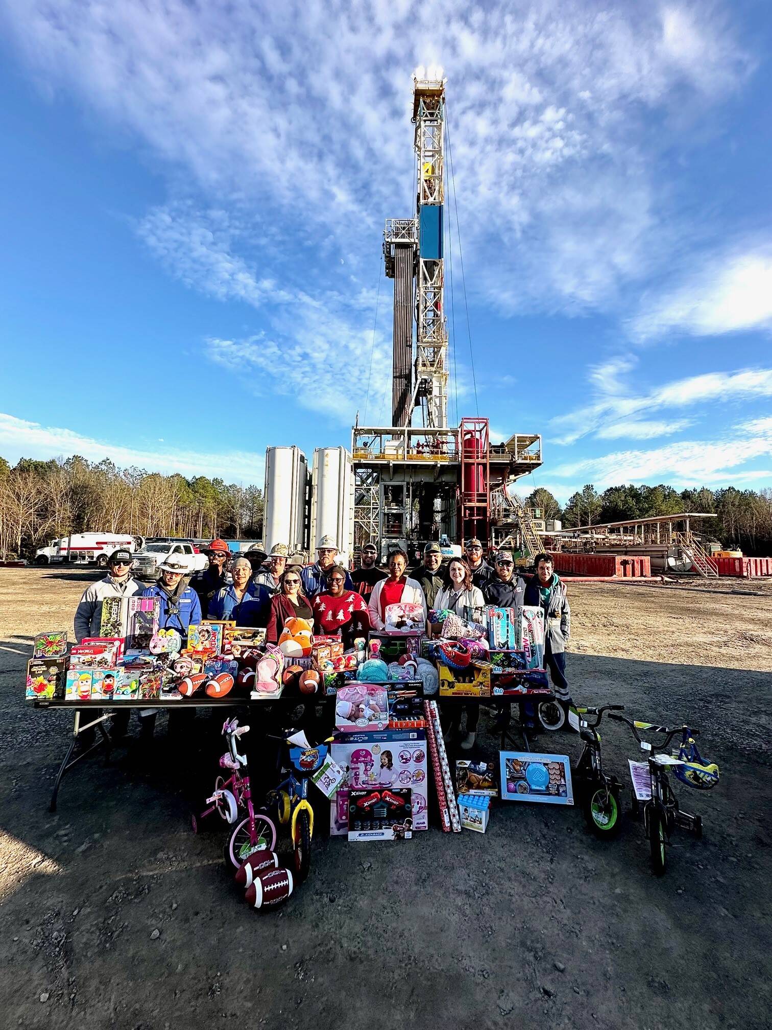 Group of people holding kids toys in front of Lithium wells