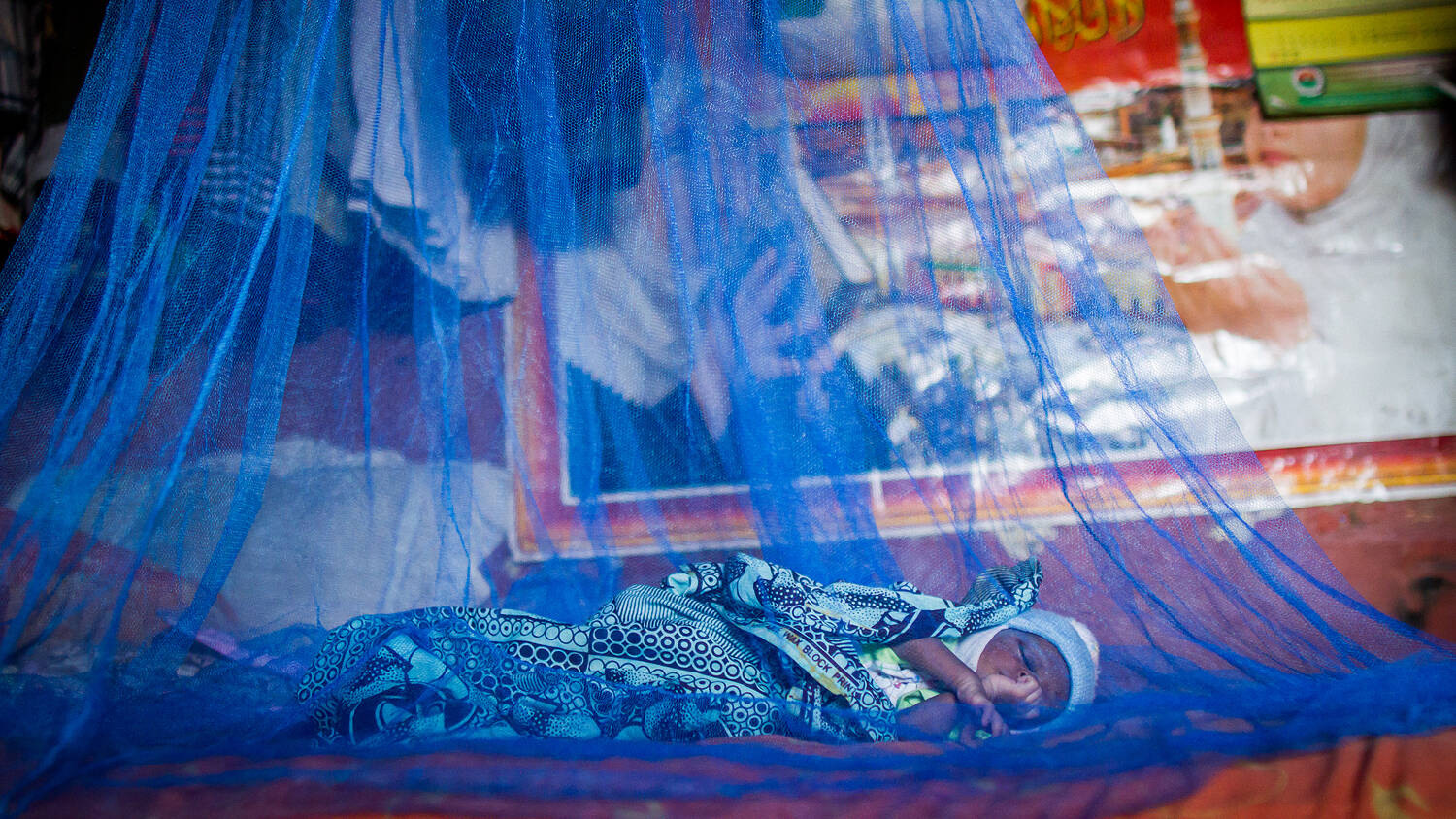 Child sleeping under a bug net