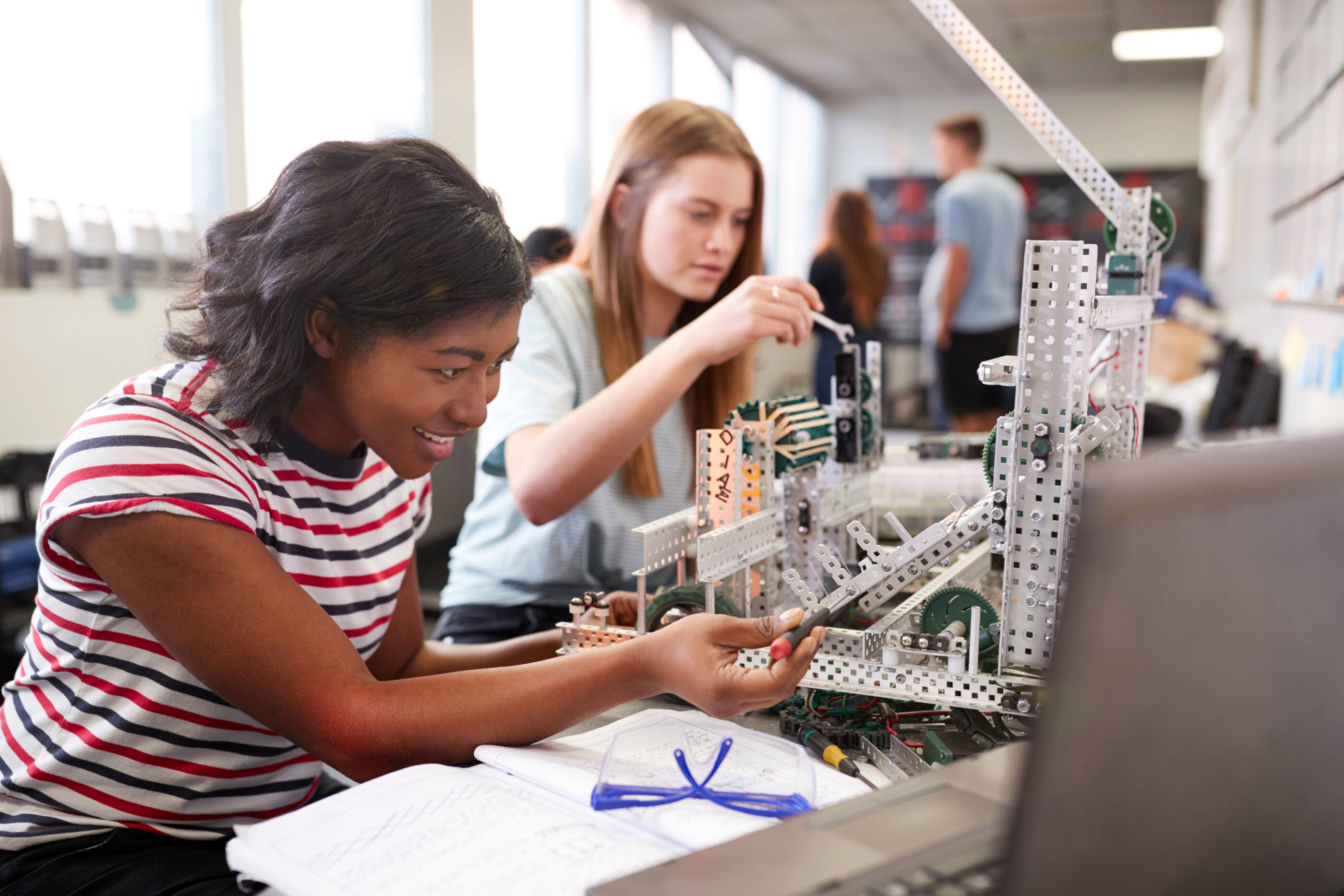 Two Female College Students Building Machine In Science Robotics Or Engineering Class