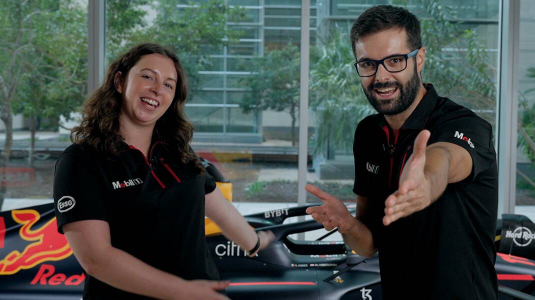 ExxonMobils racing team posing in front of racecar. 