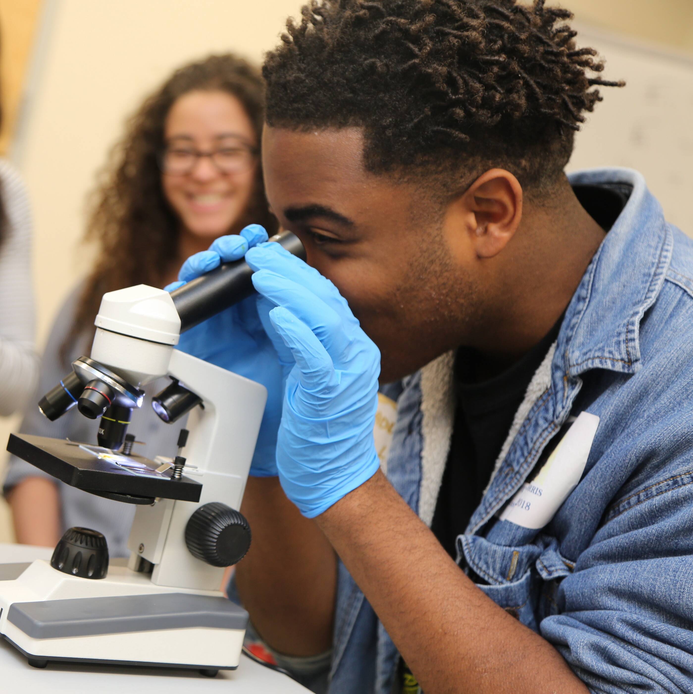 Students in a classroom looking through a microscope.