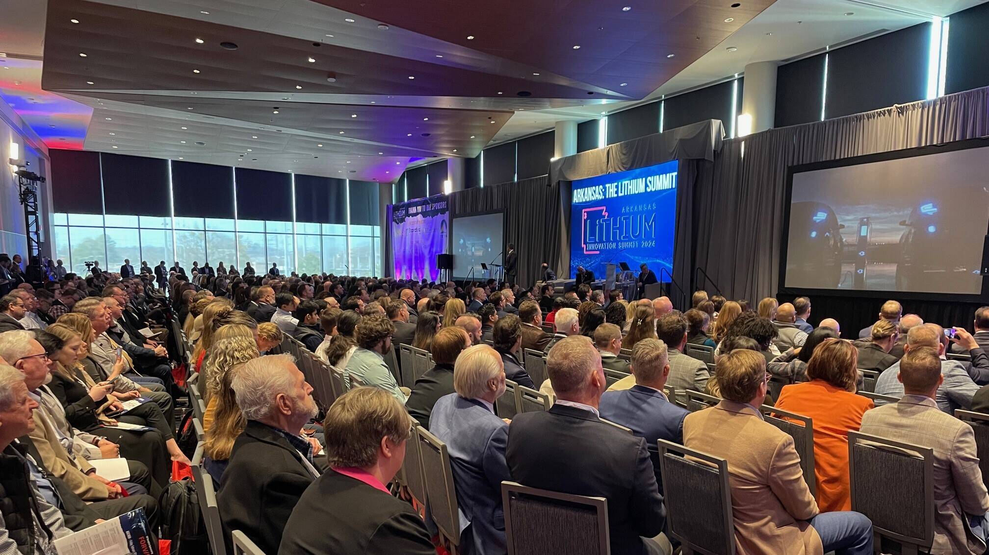 A large room with people watching a presentation